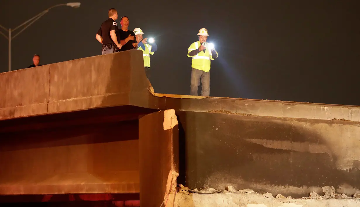 Petugas berwenang menyelidiki runtuhnya jembatan layang di jalur Interstate 85 di Atlanta, AS, Kamis (30/3). Kebakaran hebat yang terjadi di kolong jembatan itu menyebabkan jembatan layang tersebut rapuh dan runtuh. (AP Photo/David Goldman)