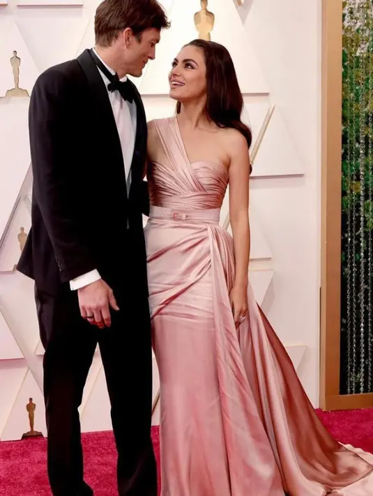 Tampil begitu mesra, Ashton Kutcher memilih tuksedo klasik dengan dasi kupu-kupu. Sementara Mila Kunis tampil anggun kenakan gaun blush pink. (Instagram/fashionbombdaily).