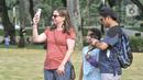 Wisatawan asing mengabadikan Tugu Monas melalui smartphone di Jakarta Pusat, Kamis (16/6/2022). Pasca ditutup sejak 2020 akibat pandemi Covid-19, Pemerintah Provinsi DKI Jakarta melakukan uji coba pembukaan kawasan wisata Monas secara bertahap dan terbatas yang dimulai dari kawasan luar tugu. (merdeka.com/Iqbal S Nugroho)
