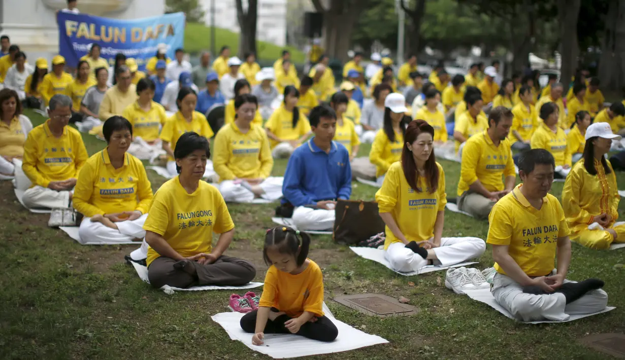 Sekelompok orang melakukan meditasi Falun Gong sebelum demonstrasi menentang pemerintah China, di luar Balaikota Los Angeles, California, Kamis (15/10). Presiden China Xi Jinping akan melakukan kunjungan kenegaraan di Washington. (REUTERS/Lucy Nicholson)