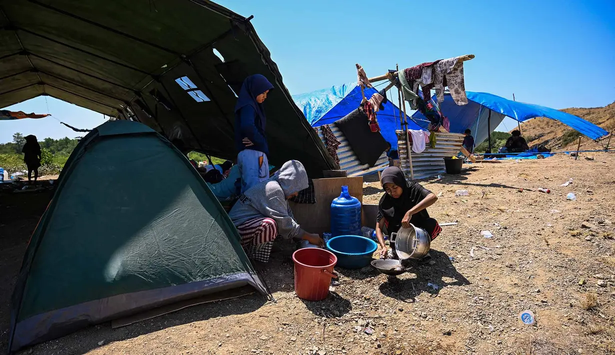 Warga mencuci peralatan masak di samping tenda di sebuah lapangan terbuka di Marapokot, Nagekeo, Nusa Tenggara Timur, Senin, 17 Agustus 2026, (AFP/ Juni Kriswanto)
