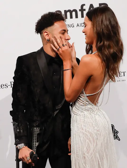 Pemain Paris Saint-Germain (PSG), Neymar dan kekasihnya yang juga model, Bruna Marquesine saling menatap mesra saat menghadiri The Foundation for AIDS Research (amfAR) Gala di Sao Paulo, Brasil, Jumat (13/4). (AP/Andre Penner)