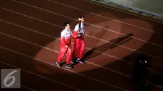 Liliyana Natsir (kiri) dan Tontowi Ahmad berlari membawa obor api PON XIX Jabar saat upacara pembukaan di Stadion Gelora Bandung Lautan Api, Bandung, Sabtu (17/9). PON XIX Jabar berlangsung hingga 29 September. (Liputan6.com/Helmi Fithriansyah)