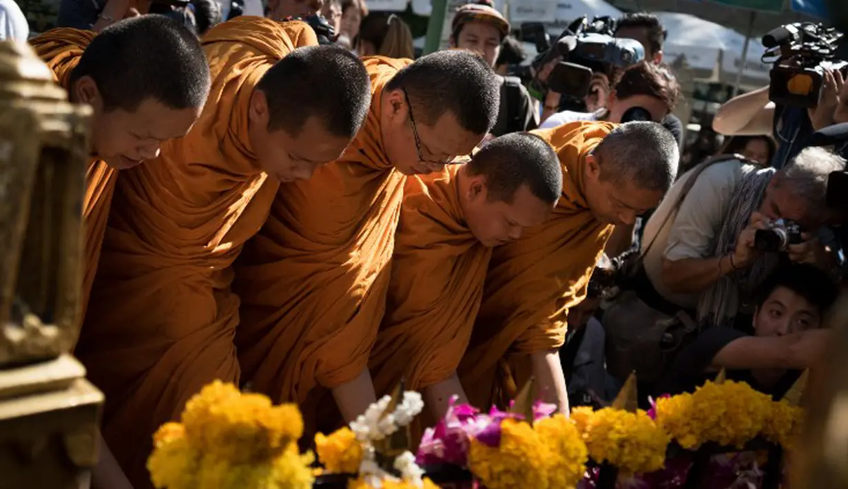 Sejumlah biksu memimpin doa untuk pembukaan kembali Kuil Erawan yang sempat ditutup karena peristiwa ledakan bom pada Senin (17/8), Bangkok, Rabu (19/8/2015). Peristiwa tersebut dikabarkan telah menewaskan sekitar 20 orang. (AFP Photo/Jerome Taylor)