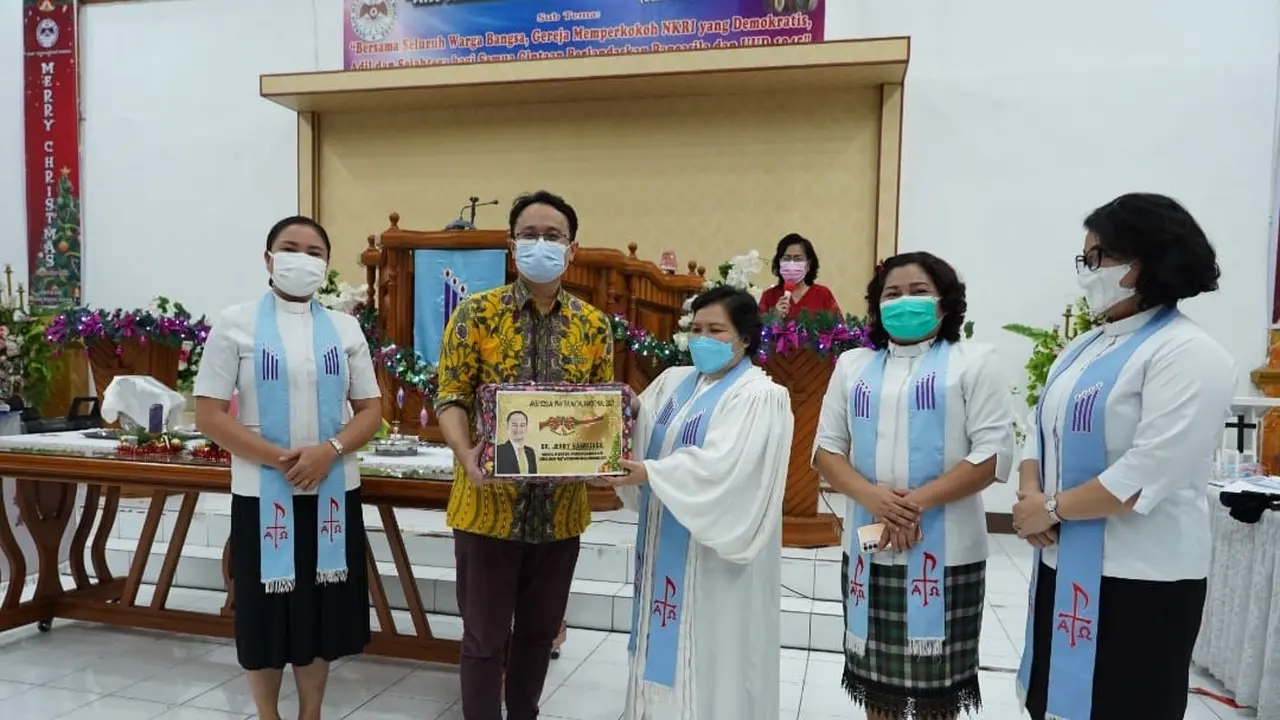 Jerry Sambuaga membagikan bingkisan Natal ke jemaat gereja di Sulut. (Istimewa)