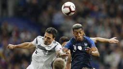 Pemain Prancis, Presnel Kimpembe, duel udara dengan bek Jerman, Mats Hummels, pada laga UEFA Nations League di Stade de France, Paris, Selasa (16/10/2018). Prancis menang 2-1 atas Jerman. (AP/Christophe Ena)