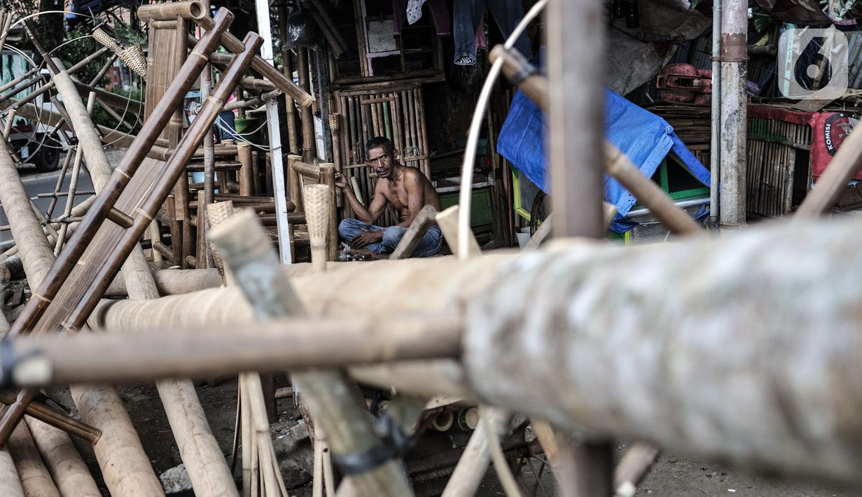 Seorang pedagang, Arifin duduk di dekat pohon pinang yang dijualnya di Jalan Manggarai Utara, Jakarta, Selasa (11/8/2020). Penjualan pohon pinang tahun ini menurun drastis dibandingkan tahun sebelumnya akibat pandemi Covid-19 yang menyebabkan larangan sejumlah perlombaan. (merdeka.com/Iqbal Nugroho)