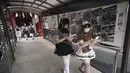 Karyawan mengenakan kostum pelayan dari beberapa kafe bertema pembantu di Akihabara berjalan setelah pertemuan doa untuk perlindungan dari COVID-19 dan untuk bisnis yang berkembang di kuil Kanda Myojin, Tokyo (25/7/2020). (AP Photo/Eugene Hoshiko)