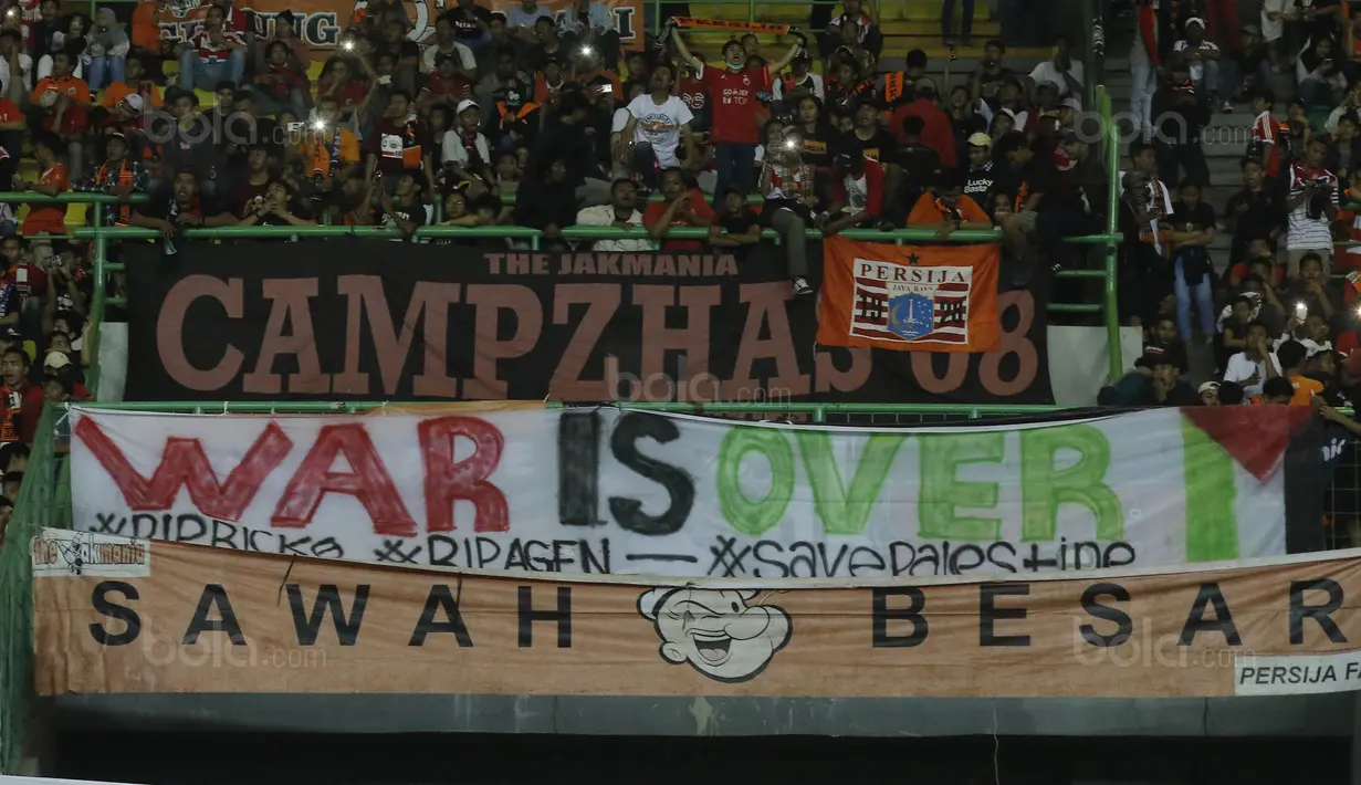 Suporter Persija, The Jakmania, membentangkan spanduk solidaritas saat melawan Bhayangkara FC pada laga Liga 1 di Stadion Patriot Bekasi, Jawa Barat, Sabtu (29/7/2017). Persija menang 1-0 atas Bhayangkara FC. (Bola.com/M Iqbal Ichsan)