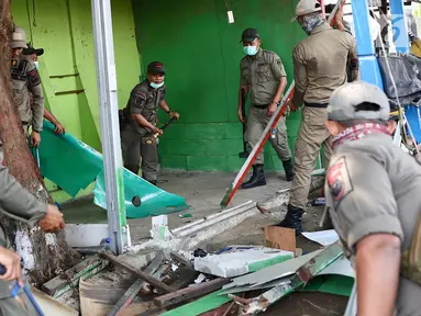 Petugas Satpol PP membongkar bangunan semi permanen di Jalan Nusantara Raya, Depok, Jawa Barat, Rabu (18/4). Pembongkaran dilakukan untuk menertibakan bangunan liar yang berdiri di sepanjang trotoar. (Liputan6.com/Immanuel Antonius)