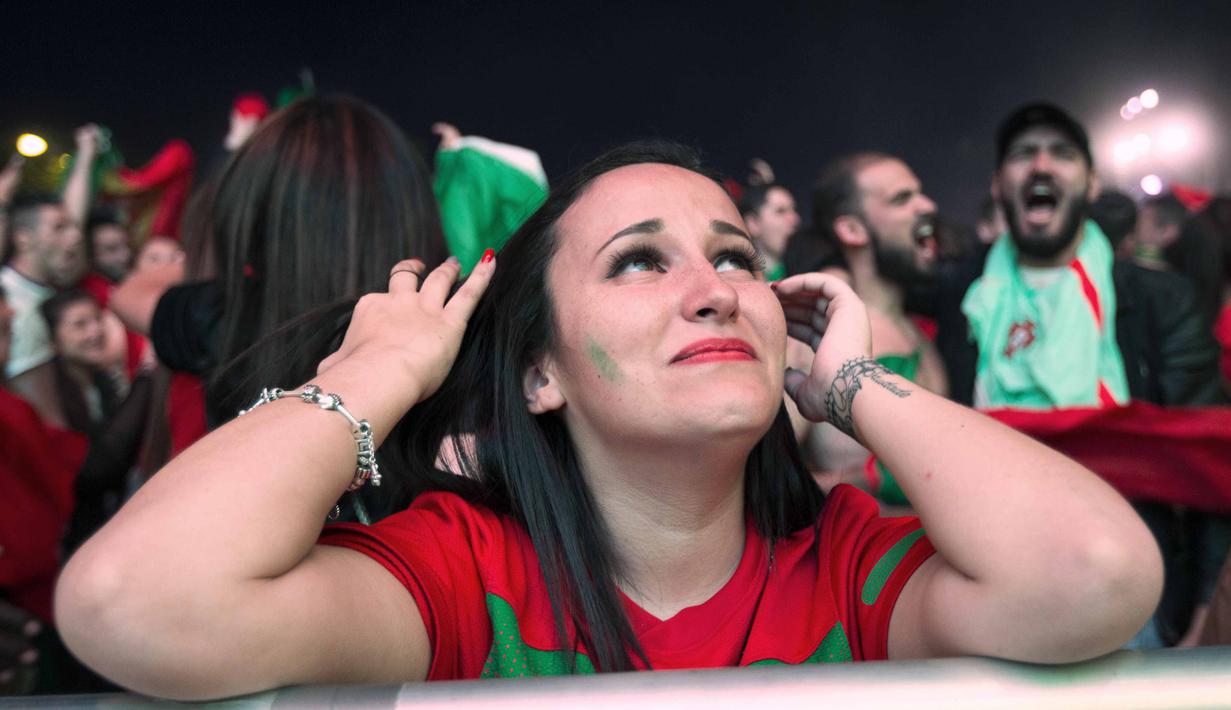 Fans cantik Portugal terlihat mengis bahagia saat timnya menang atas Wales pada semi-final Piala Eropa 2016 di Fans Zone Champ de Mars,  Paris, Kamis  (7/7/2016) dini hari WIB. (AFP/Geofroy Van Der Hasselt)