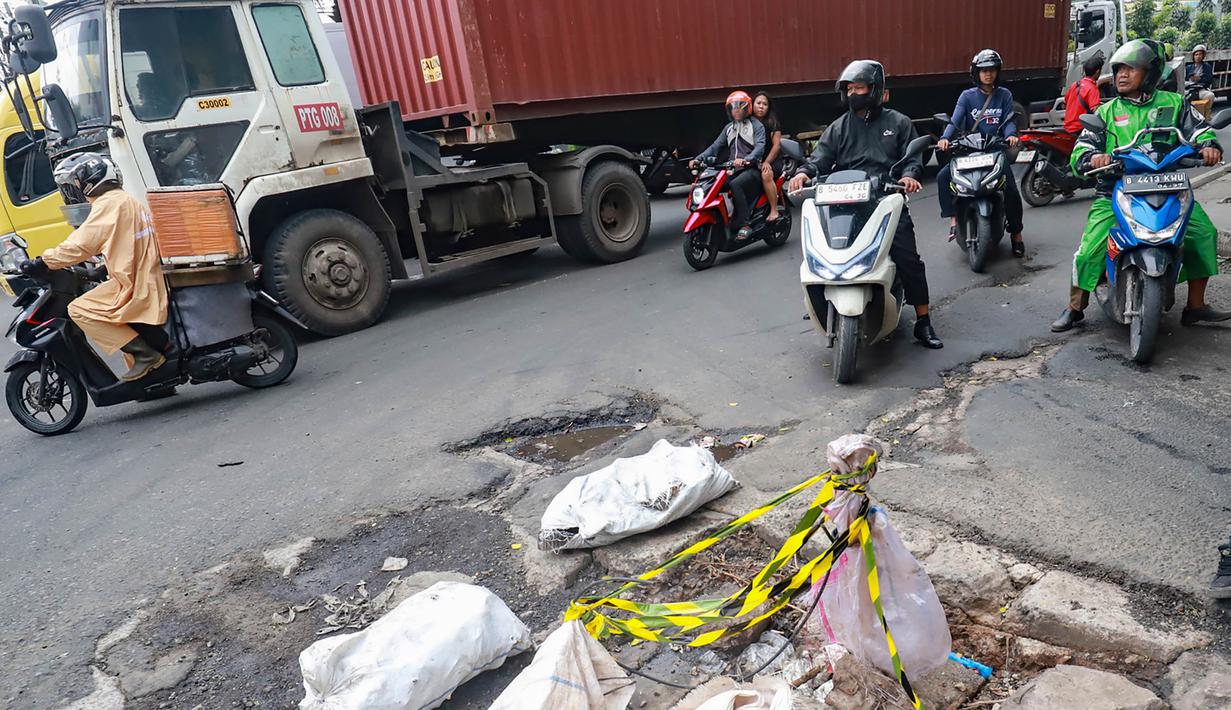 Upaya ini diharapkan dapat mengurangi potensi kecelakaan serta memperlancar mobilitas masyarakat di tengah musim hujan. Tampak dalam foto, sejumlah pengendara melewati kerusakan di Jalan Gedong Panjang, Penjaringan Jakarta Utara, Selasa (3/2/2026). (merdeka.com/Arie Basuki)