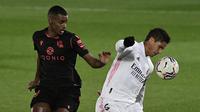 Bek Real Madrid, Raphael Varane (kanan) menguasai bola dibayangi striker Real Sociedad, Alexander Isak dalam laga lanjutan Liga Spanyol 2020/21 pekan ke-25 di Alfredo di Stefano Stadium, Madrid, Senin (1/3/2021). Real Madrid bermain imbang 1-1 dengan Real Sociedad. (AFP/Javier Soriano)