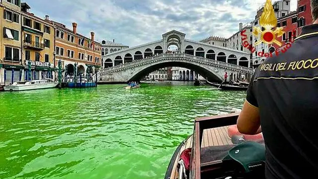 Petugas pemadam kebakaran Italia di atas kapal sedang melihat ke Jembatan Rialto.