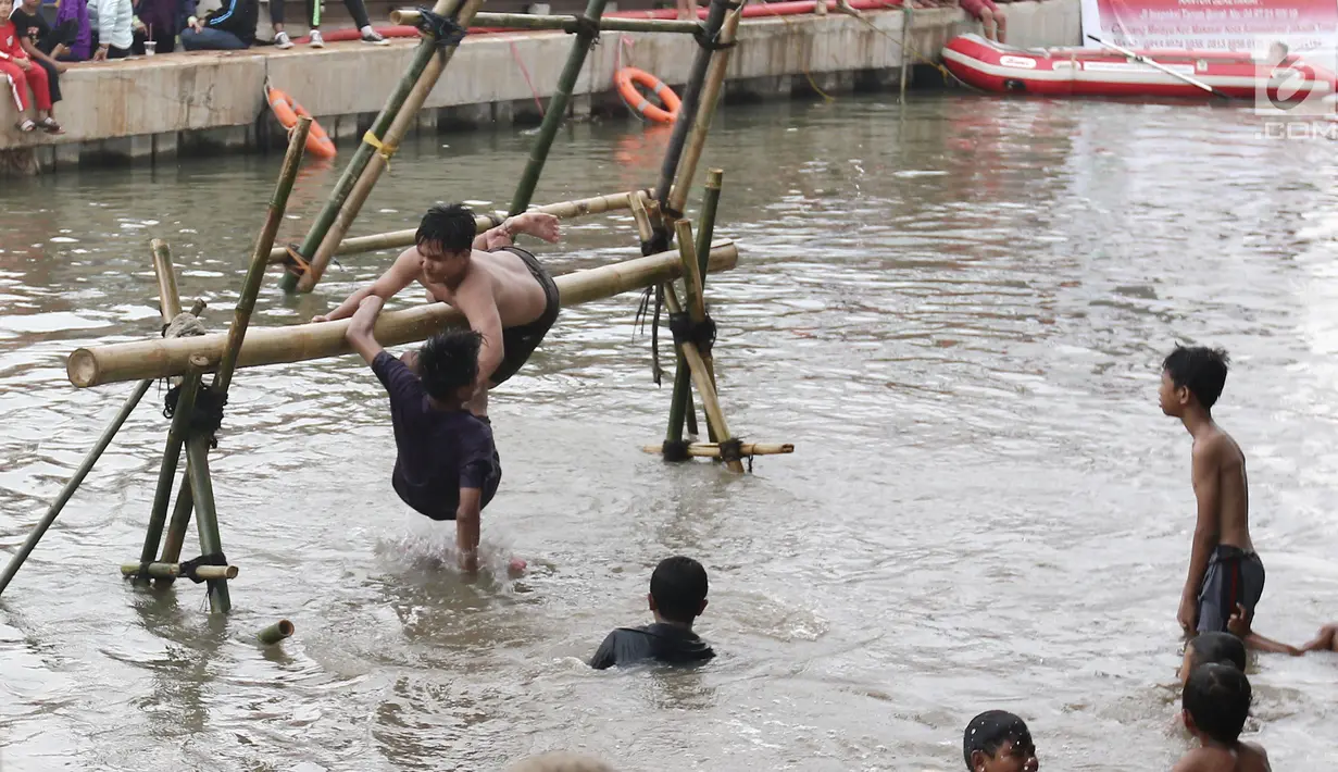 Seorang peserta terjatuh ke air saat mengikuti lomba gebuk bantal dalam Festival Kalimalang di Cipinang Melayu, Jakarta Timur, Kamis (17/8). Festival Kalimalang ini dalam rangka memeriahkan HUT ke-72 RI. (Liputan6.com/Herman Zakharia)