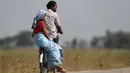 Seorang pria India bersama istrinya mengenakan sepeda di pinggiran Gauhati, India (16/11/2019). Lebih dari 70 persen dari 1,25 miliar penduduk India terlibat dalam pertanian. (AP Photo/Anupam Nath)