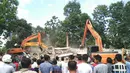 Warga menyaksikan evakuasi korban gempa 6,4 SR di Kabupaten Pidie Jaya, Aceh, Rabu (7/12). Kondisi terakhir ada 98 unit ruko roboh. Di Trienggadeng ada 15 rumah rusak berat," kata Puteh. (AFP PHOTO/Chaideer Mahyuddin)