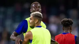 Gelandang Manchester United, Paul Pogba berbincang dengan rekannya Andreas Pereira selama sesi latihan terbuka jelang pertandingan tur pramusim melawan Perth Glory di Stadion Optus, Perth (11/7/2019). MU dijadwalkan menggelar tur pramusim di Australia, Tiongkok, dan Singapura. (AFP Photo/Tony Ashby)