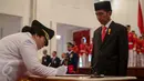 Irene Manibuy menandatangani surat pelantikan dirinya disaksikan Presiden Joko Widodo di Istana Negara, Jakarta, Rabu (27/5/2015). (Liputan6.com/Faizal Fanani)