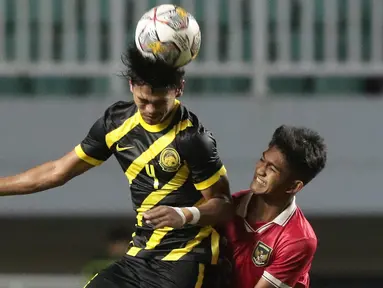 Pemain Timnas U-17 Indonesia, M Narendra Tegar (kanan) berebut bola dengan Adib Ibrahim Adnan (Malaysia U-17) pada laga terakhir Kualifikasi Grup B Piala Asia U-17 2023 di Stadion Pakansari, Kab. Bogor, Jawa Barat, Minggu (9/10/2022). Laga kedua tim berlangsung sengit dan Timnas U-17 Indonesia menelan pil pahit kekalahan dari Malaysia U-17 dengan skor 1-5. (Liputan6.com/Helmi Fithriansyah)