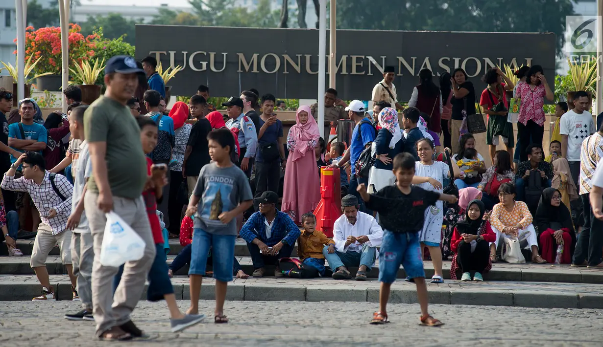 Pengunjung menikmati liburan di kawasan Monumen Nasional (Monas) ) saat hari libur Lebaran hari kedua, Jakarta, Kamis (6/6/2019). Kawasan Monas merupakan salah satu tempat favorit bagi masyarakat Jakarta atupun luar Jakarta untuk berlibur. (merdeka.com/Imam Buhori)