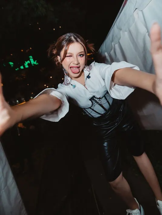 Sedikit lebih playful, Tiara Andini padukan kemeja hitam, korset transparan, dan latex pants [instagram/tiaraandini]