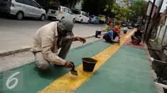 Pekerja menyelesaikan pembangunan Trotoar Ramah Disabilitas di Jalan Hidup Baru, Kalimati, Jakarta Utara, Selasa (27/12). Nantinya trotoar ini akan dibangun sepanjang 753 meter dan lebar 2,4 meter. (Liputan6.com/Gempur M. Surya)