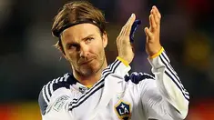 Gelandang LA Galaxy David Beckham memberi sambutan ke arah fans pada lanjutan Major League Soccer melawan DC United di Carson, California. Victor Decolongon/Getty Images/AFP