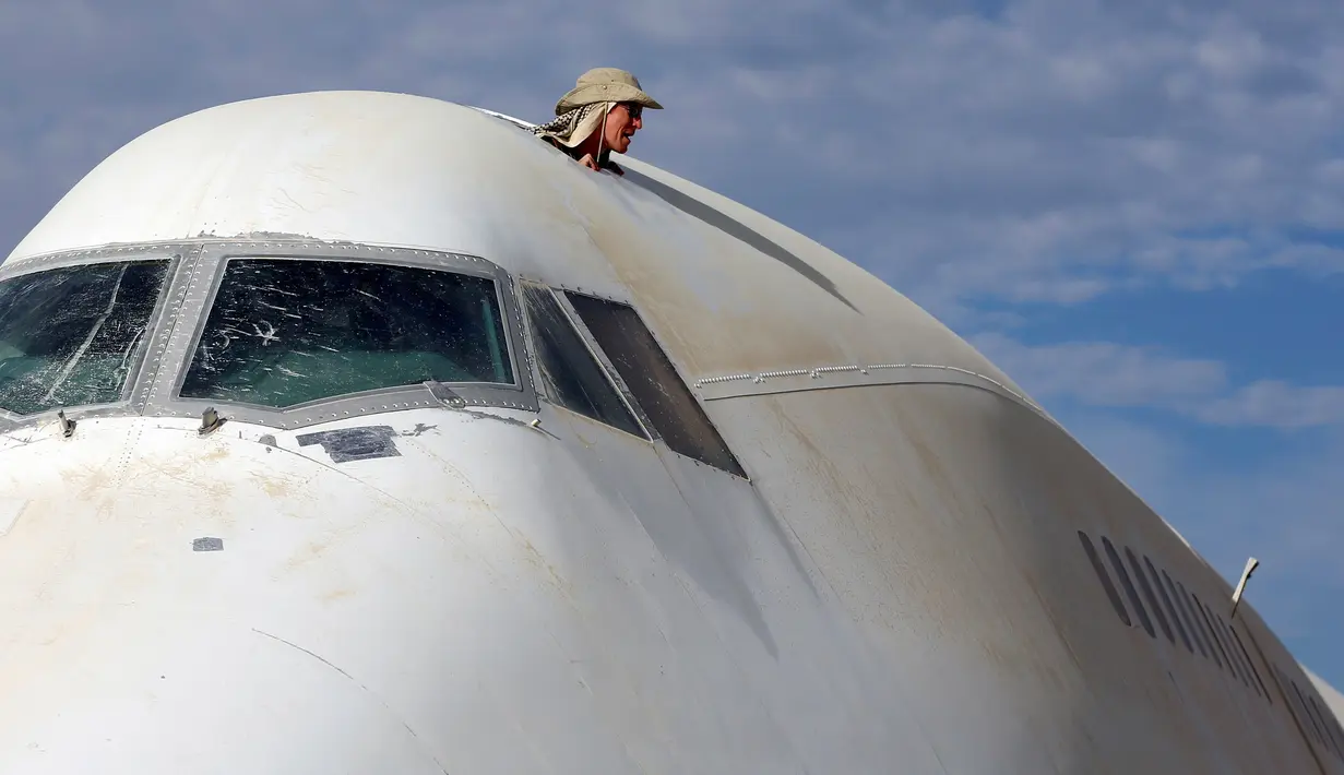 Seorang peserta terlihat dari atas pesawat Boeing 747 di Festival Burning Man, di padang pasir Black Rock, Nevada, Amerika Serikat (29/08). Festival ini sebelumnya digelar dengan tujuan komersil di bawah nama Black Rock City. (REUTERS/Jim Urquhart)