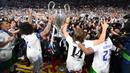 Pemain Real Madrid Marcelo (kedua dari kiri) dan Luka Modric (kedua dari kanan) memegang trofi kemenangan Liga Champions usai mengalahkan Liverpool di Stade de France, Saint-Denis, Prancis, 28 Mei 2022. Real Madrid mengalahkan Liverpool 1-0. (FRANCK FIFE/AFP)