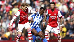 Pemain Arsenal Martin Odegaard (kiri), berduel memperebutkan bola dengan pemain Brighton Danny Welbeck dalam pertandingan lanjutan Liga Inggris di Stadion Emirates, Sabtu (9/4/2022) malam WIB. (AP Photo/Ian Walton)