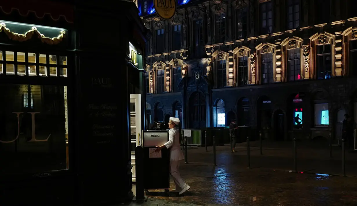 Seorang pelayan menutup teras bar di Lille, Prancis, Jumat (16/10/2020). Prancis mengerahkan 12.000 polisi untuk memberlakukan jam malam baru mulai Jumat malam hingga bulan depan untuk memperlambat penyebaran COVID-19. (AP Photo/Michel Spingler)