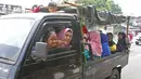 Sejumlah warga berpergian dengan menggunakan mobil bak terbuka di kawasan Jakarta, Minggu (9/6/2019). Warga memanfaatkan truk dan mobil bak terbuka untuk bepergian bersama keluarga menuju sejumlah objek wisata karena dianggap lebih hemat biaya. (Liputan6.com/Herman Zakharia)