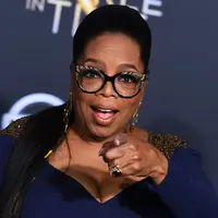 Aktris sekaligus presenter, Oprah Winfrey menghadiri premier film "A Wrinkle In Time" di Hollywood’s El Capitan Theater, Los Angeles, Senin (26/2). Oprah Winfrey datang dalam balutan Atelier Versace mididress warna navy. (Jordan Strauss/Invision/AP)