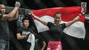 Petarung putri Indonesia, Priscilla Hertati Lumban Gaol membawa bendera merah putih usai mengalahkan petarung putri Malaysia, Audreylaura Boniface saat berlaga pada partai pertama One Championship di Jakarta, Sabtu (20/1). (Liputan6.com/Faizal Fanani)
