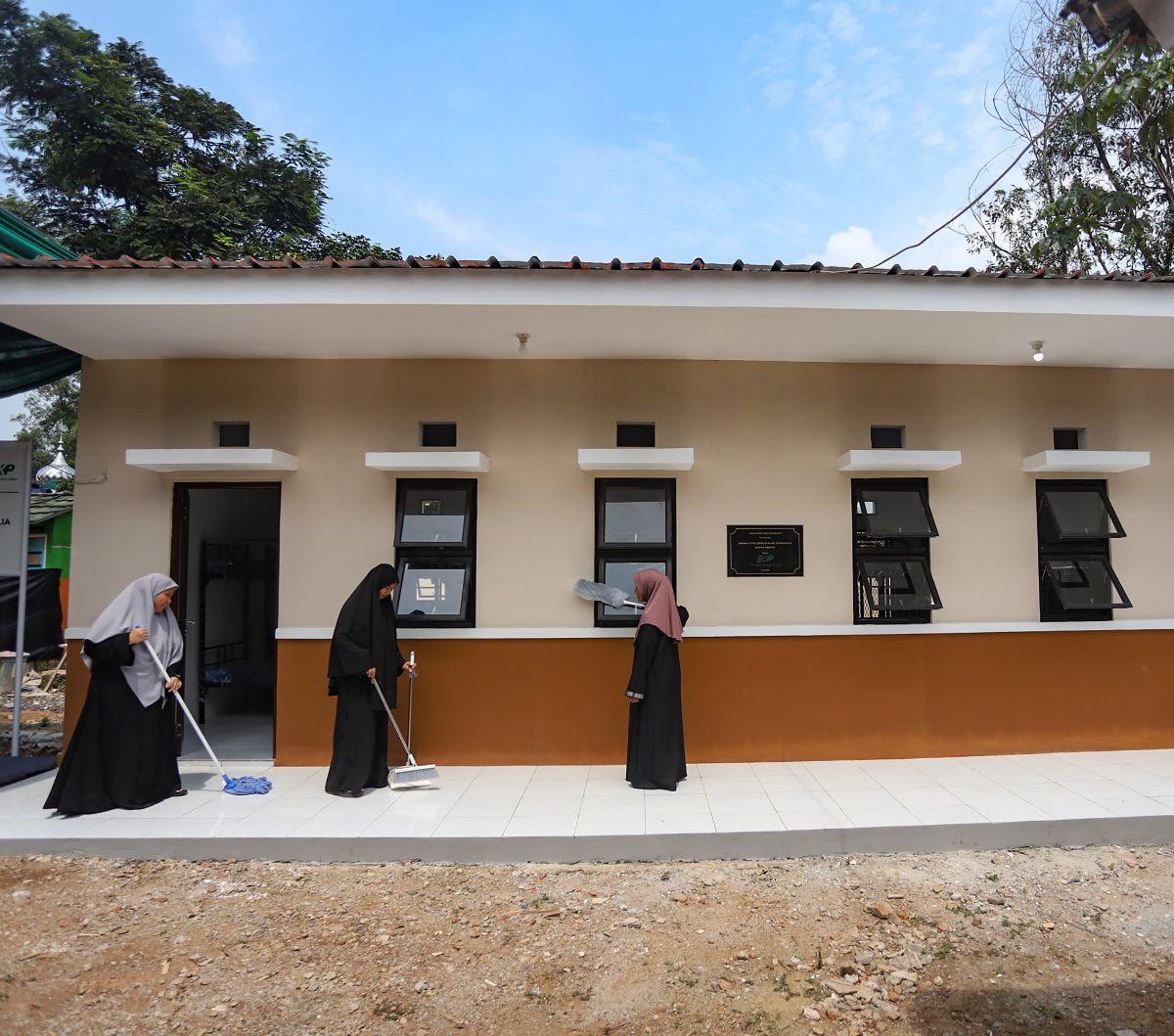Sejumlah siswi Sekolah Alam Tunas Mulia membersihkan bangunan asrama baru di kawasan Tempat Pengolahan Sampah Terpadu (TPST) Bantar Gebang, Bekasi, Jawa Barat, Kamis (2/5/2024). Pada momen Hari Pendidikan Nasional (Hardiknas), siswa dan siswi Sekolah Alam