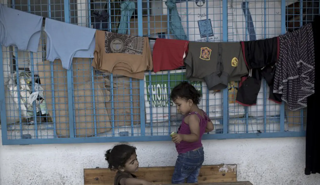 Dua orang anak Palestina saat tengah bermain di kamp pengungsi Sekolah PBB di Jabalia, Gaza (28/7/14). (AFP PHOTO/Mahmud HAMS)