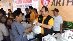 Penyerahan paket sembako murah oleh direktur Bank Artha Graha Andy Kasih kepada warga Sawah Besar, Jakarta, Minggu (24/1/2014). (Media Center AGN - AGP)
