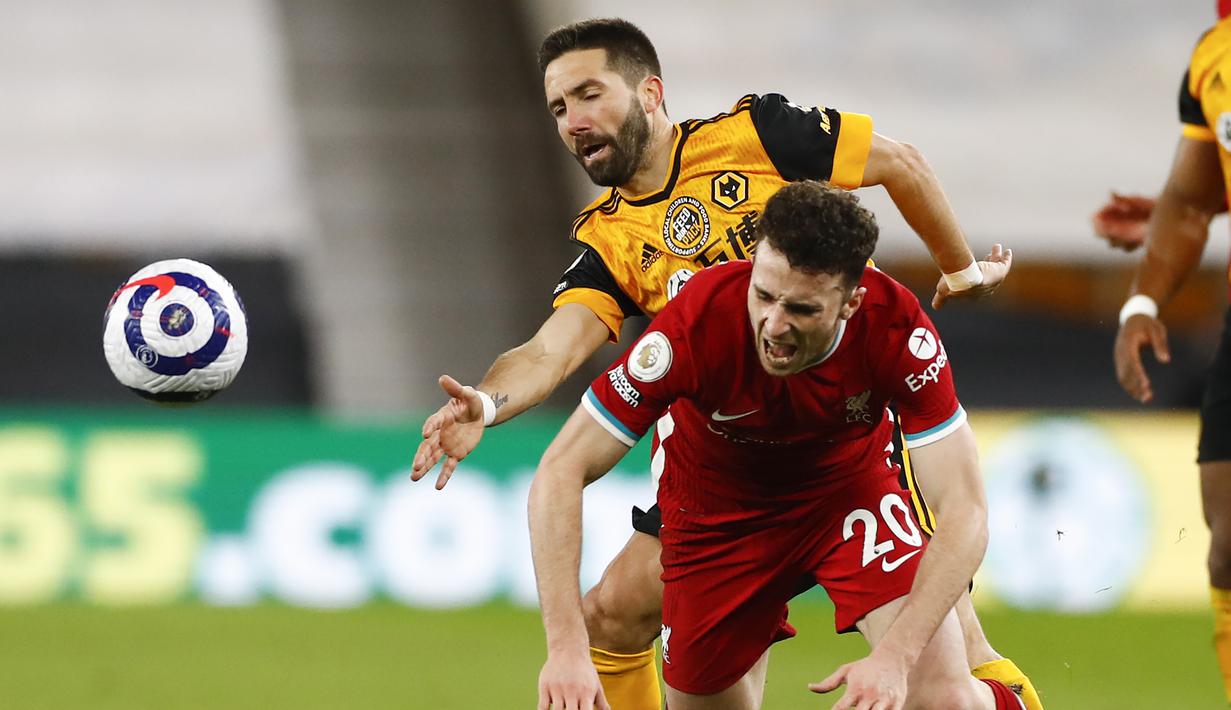 Striker Liverpool, Diogo Jota (kanan) berebut bola dengan gelandang Wolverhampton Wanderers, Joao Moutinho dalam laga lanjutan Liga Inggris 2020/2021 pekan ke-28 di Molineux Stadium, Senin (15/3/2021). Liverpool menang 1-0 atas Wolverhampton. (AP/Jason Cairnduff/Pool)