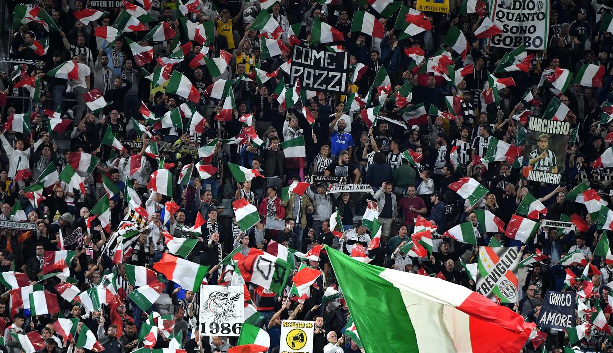 Suporter Juventus, mengibarkan bendera Italia saat mendukung timnya melawan Fiorentina pada  anjutan Serie A di Allianz Stadium, Turin, (20/9/2017). Juventus menang 1-0. (AFP/Alberto Pizzoli)