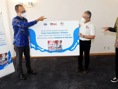 Corporate Affairs Director FFI Andrew F. Saputro (kiri) bersama Corcomm GM Alfamart Nur Rachman (kanan) secara simbolis menyerahkan produk donasi berupa 100 ribu kotak susu cair anak FRISIAN FLAG Milky kepada CEO FOI Hendro Utomo (tengah) di Jakarta, Jumat (15/10/2021). (Liputan6.com/HO/FFI)