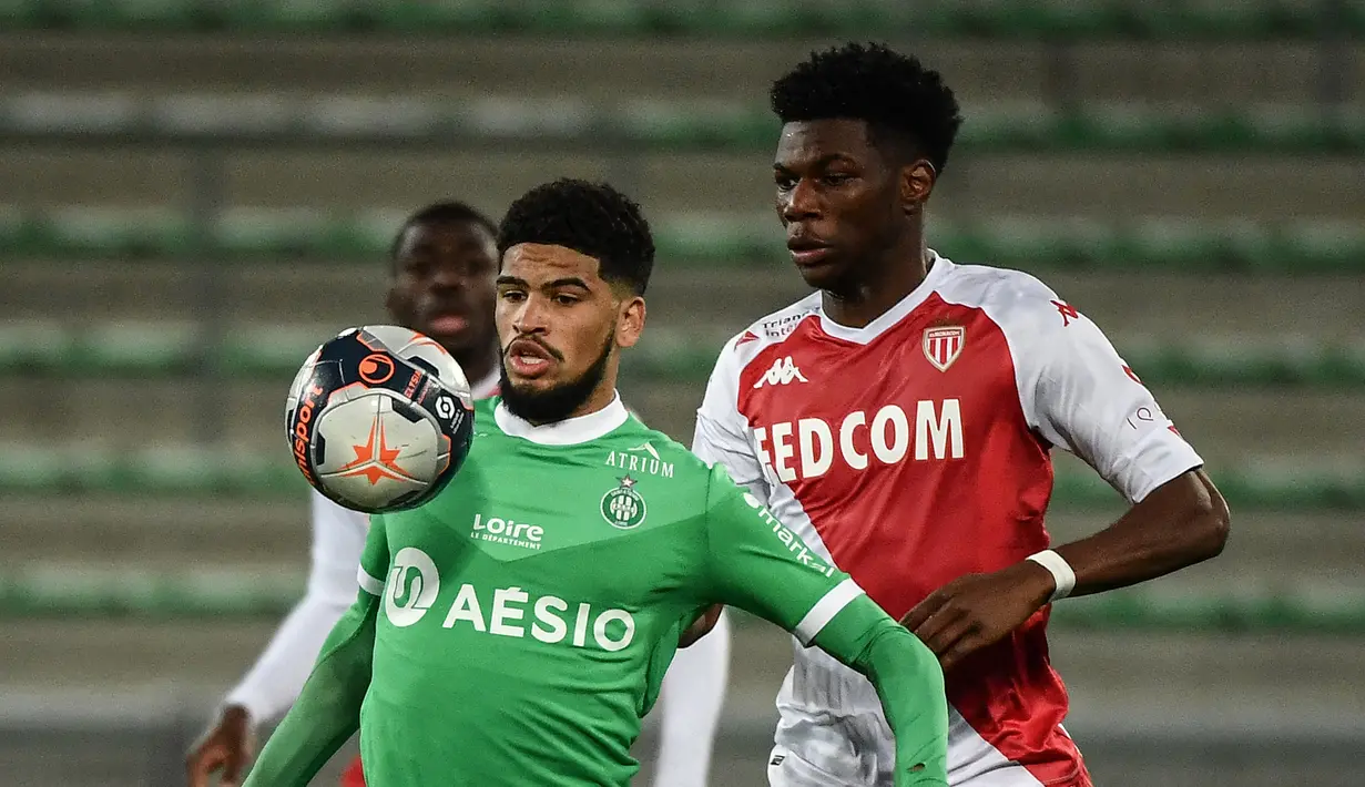 Gelandang Saint-Etienne, Mahdi Camara (kiri) menguasai bola dibayangi gelandang AS Monaco, Aurelien Tchouameni dalam laga lanjutan Liga Prancis 2020/2021 pekan ke-30 di Geoffroy Guichard Stadium, Jumat (19/3/2021). Saint-Etienne kalah 0-4 dari Monaco. (AFP/Jeff Pachoud)