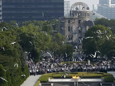 Burung Merpati terbang di atas Peace Memorial Park, dengan latar Monumen Bom Atom, pada saat upacara peringatan 70 tahun jatuhnya bom atom di Hiroshima, Jepang (6/8/2015). 140.000 penduduk Jepang tewas akibat Bom Atom. (REUTERS/Toru Hanai)