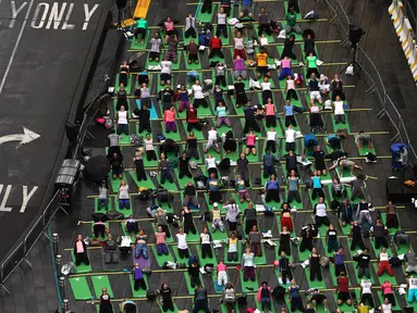 Ribuan orang berpartisipasi dalam yoga outdoor di kawasan Times Square, New York saat Summer Solstice atau hari dengan siang terpanjang di musim panas, Kamis (21/6). Acara itu menandai Hari Yoga Internasional yang jatuh pada 21 Juni (TIMOTHY A. CLARY/AFP)