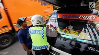 Petugas kepolisian memberi surat tilang ke pengendara saat Operasi Zebra Jaya 2017 di Daan Mogot, Jakarta, Selasa (7/11). Operasi Zebra yang digelar 1 November- 14 Desember 2017 tersebut secara serentak dilakukan se-Indonesia. (Liputan6.com/Johan Tallo)