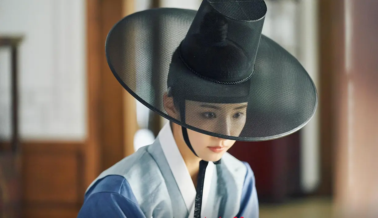 Kang Hee Soo memakai gat (topi tradisional Korea) dan mengenakan pakaian pria berwarna biru saat ia menyamar sebagai pria. Dia tampil elegan dan sikapnya memadukan visual tampan dan cantik. (Foto: tvN)