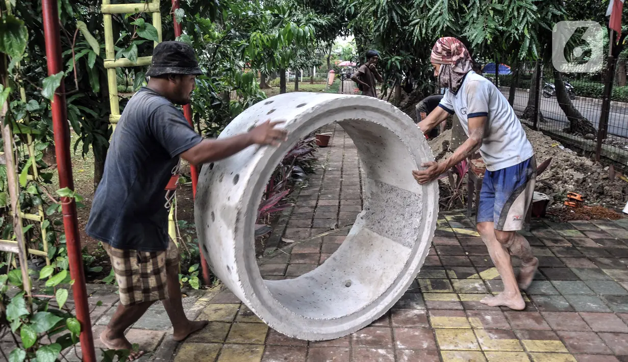 Pekerja menyelesaikan pembangunan sumur resapan di RPTRA Meruya Utara, Jakarta, Selasa (25/1/2022). Pembangunan 100 titik sumur resapan ini bertujuan untuk mengantisipasi banjir yang kerap terjadi di wilayah tersebut. (merdeka.com/Iqbal S. Nugroho)