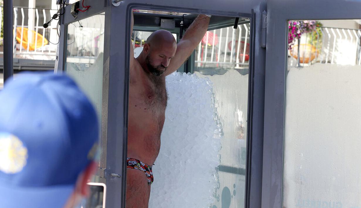 Perenang es Austria Josef Koeberl meninggalkan kabin kaca berisi es usai memecahkan rekor dunia di Melk, Austria, Sabtu (5/9/2020). Josef Koeberl berhasil memecahkan rekor dunia dengan berendam dalam es selama 2 jam, 30 menit, dan 57 detik. (AP Photo/Ronald Zak)