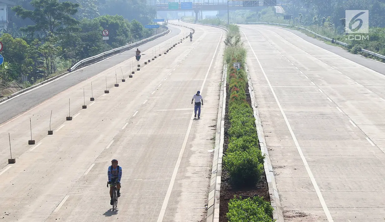 Warga berolahraga di proyek Jalan Tol Cijago Seksi II, kawasan Kukusan, Depok, Minggu (6/1). Proyek yang hampir rampung itu dimanfaatkan untuk berolahraga dengan menyusuri jalur yang belum dilalui kendaraan bermotor. (Liputan6.com/Immanuel Antonius)