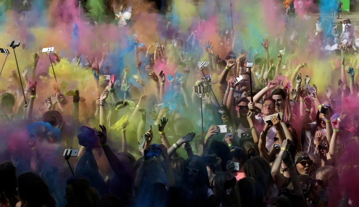 Keseruan lempar bubuk warna pada festival Holi di Riga, Latvia, (9/7). Festival ini selalu dirayakan setiap awal musim semi. (REUTERS/Ints Kalnins)